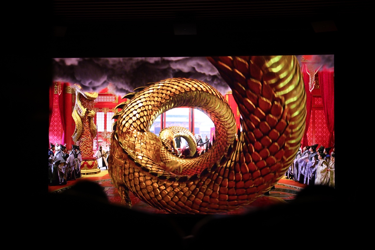 A large gold dragon on a stage Description automatically generated